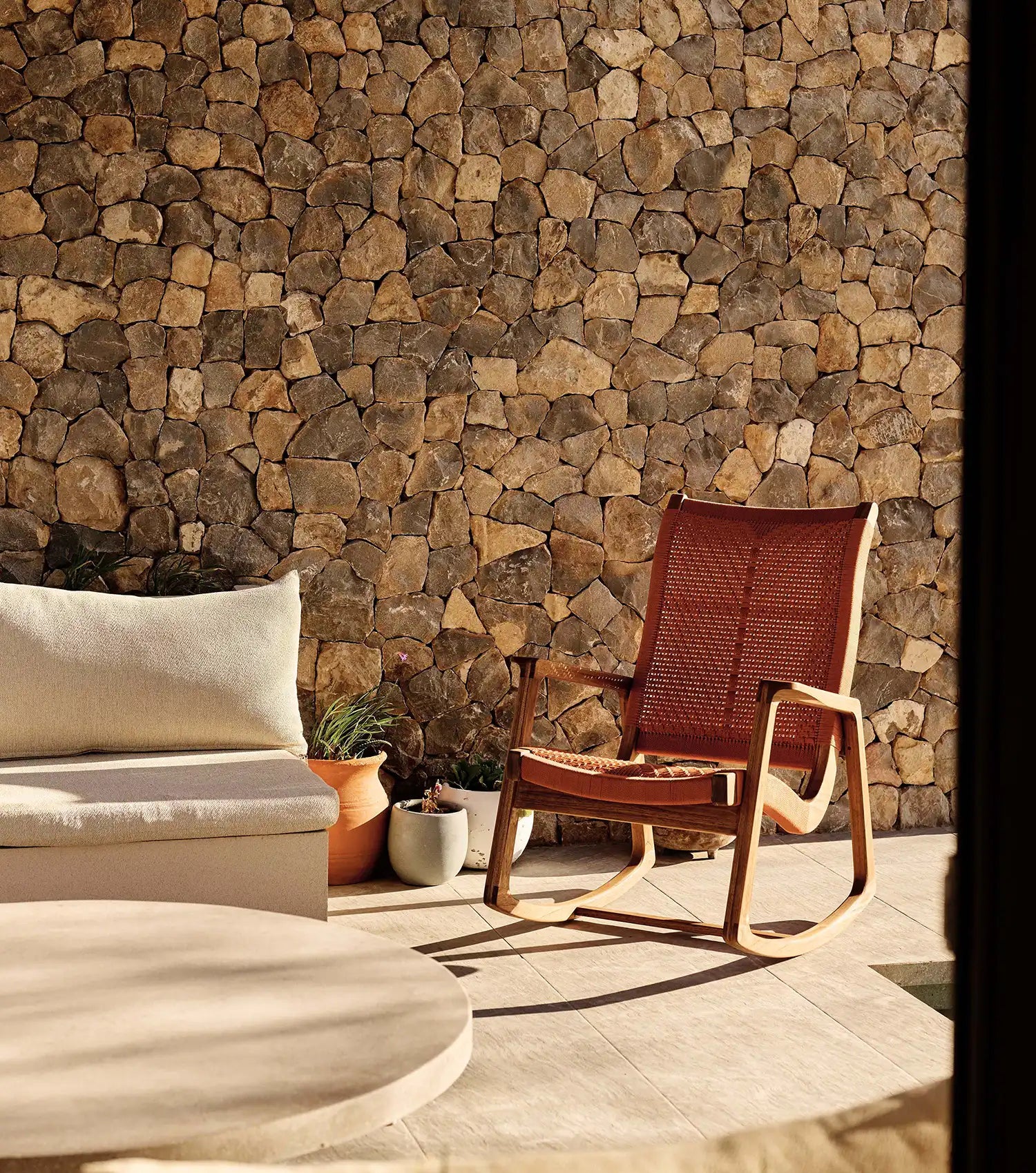 Outdoor seating area with a stone wall background