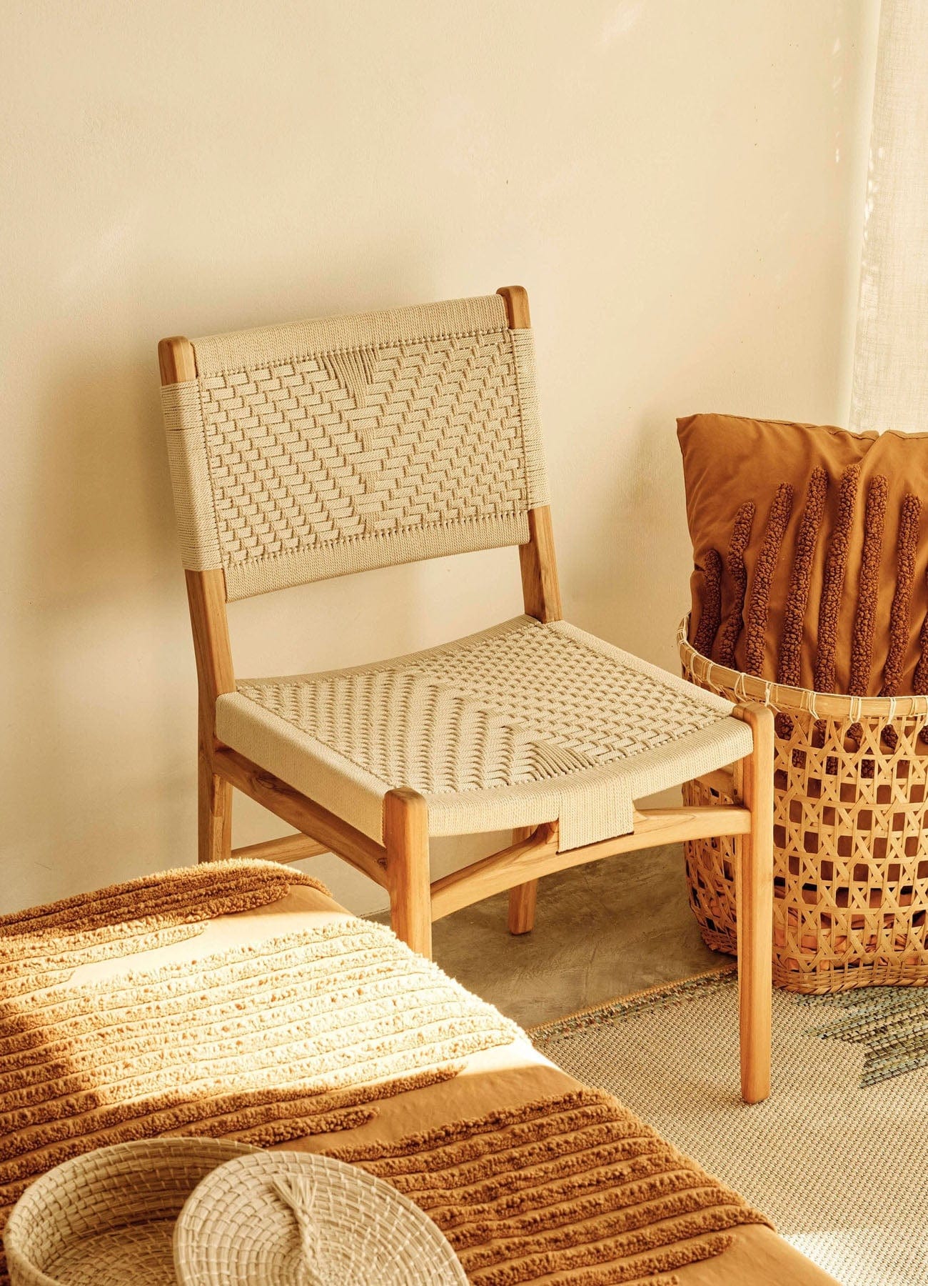 Woven rope dining chair and basket against a neutral wall