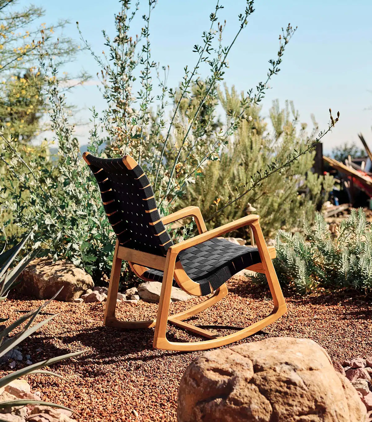 Wooden chair with black cushion in a natural outdoor setting